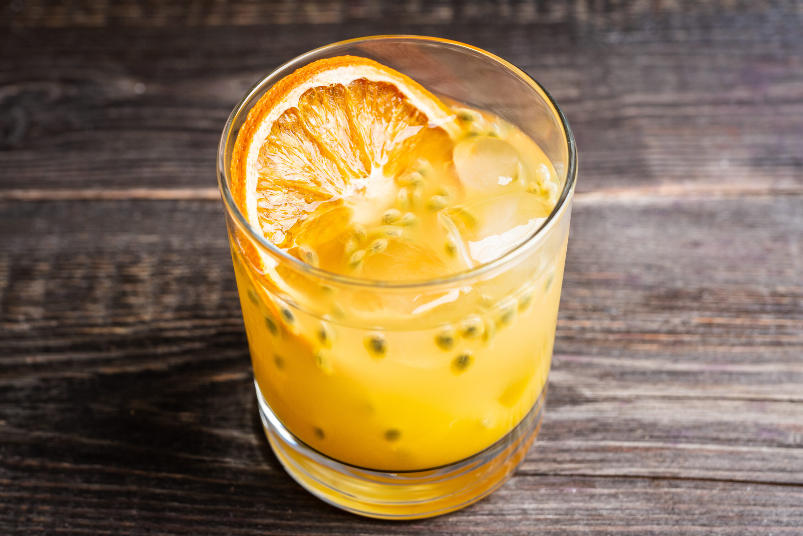 Fruit & tonic sem álcool 1 Old fahioned passion fruit cocktail on the rustic background. Selective focus. Shallow depth of field.