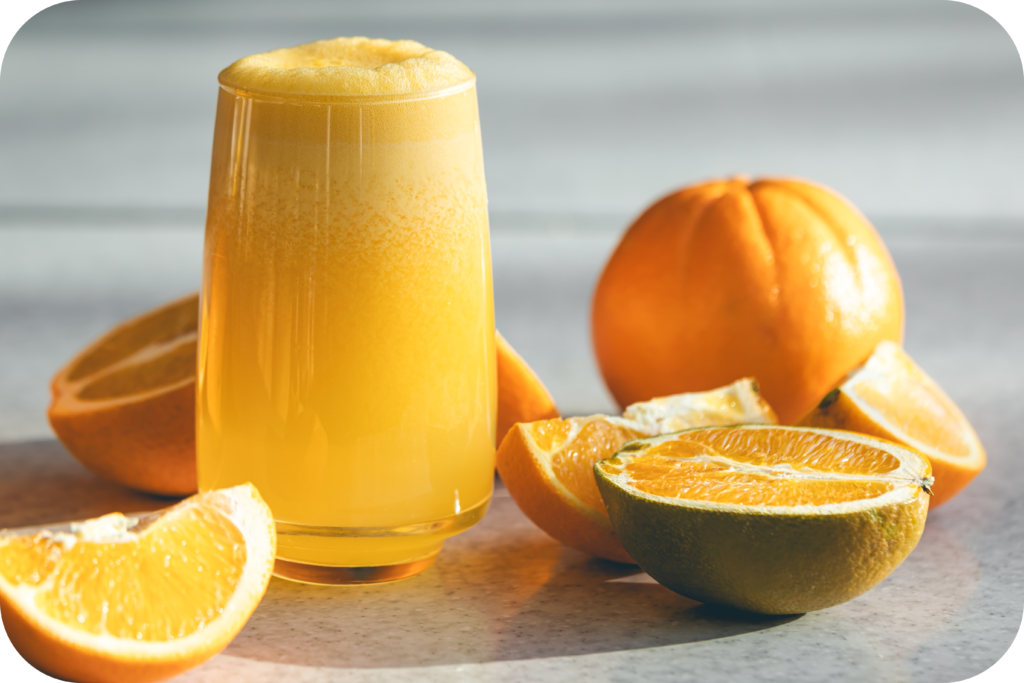 closeup glass orange juice blurred background with oranges modified