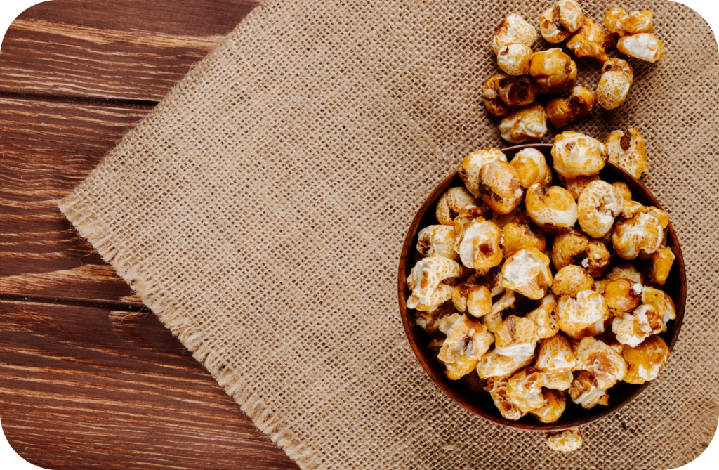 top view sweet caramel popcorn wooden bowl sackcloth rustic background with copy space modified